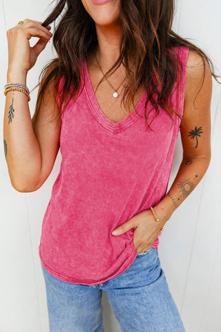 Woman wearing a vintage fuchsia tank top with a V-neck, paired with light wash jeans.