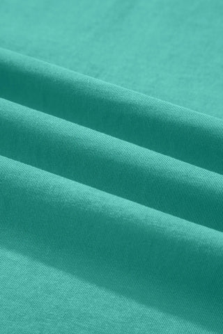 Close-up of the soft, washed teal fabric of the Canyon Teal Pocket Top, showing its texture and folds.