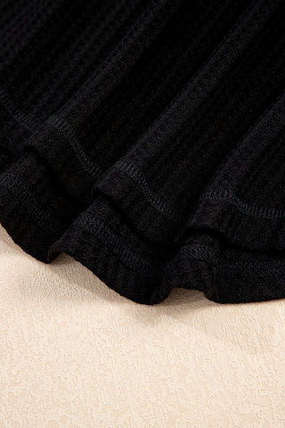 Close-up of the black Canyon Waffle Knit Top, showing the textured fabric and casual folds.