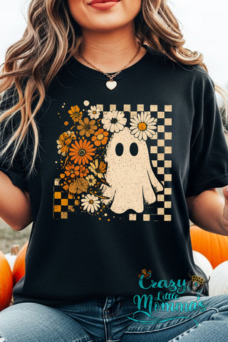 Woman wearing a black Retro Floral Ghost Tee with a checkered background and orange and white flowers.