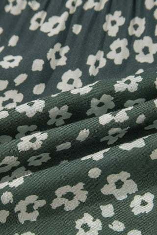 Close-up of the Cloverfield Mini Dress fabric, showing a dark olive green with small white floral patterns.