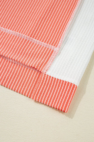 Close-up of the coral ribbed panel top, showing its textured fabric and white contrast panel.