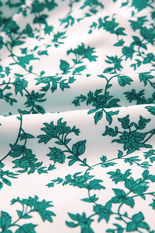 Close-up of the Country Breeze Maxi Dress fabric, showing a white background with a teal floral pattern.