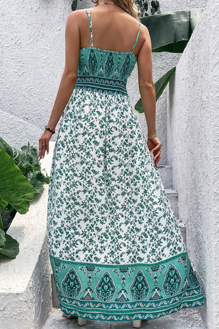 Back view of a woman wearing a white and green Bohemian Floral Maxi Dress with a detailed patterned hem.