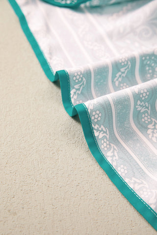 Close-up of the Country Breeze Maxi Dress fabric, showing a white and teal Bohemian floral pattern.