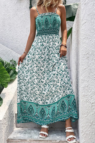 Woman in a white and green Bohemian Floral Maxi Dress with a smocked bodice and floral print.