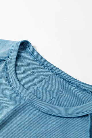 Close-up of a blue Creekside Ribbed Top, showing the ribbed crew neck and textured fabric.