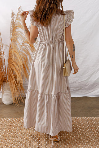 Woman from behind wearing a Daisy Lane Maxi Dress, a boho striped maxi dress with ruffled sleeves.