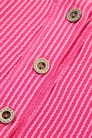 Close-up of the Desert Bloom Henley Top, showing the pink ribbed fabric with light pink wavy stripes and wooden buttons.