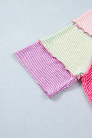 Close-up of a pink patchwork henley top with ribbed fabric in shades of pink, purple, and light green.