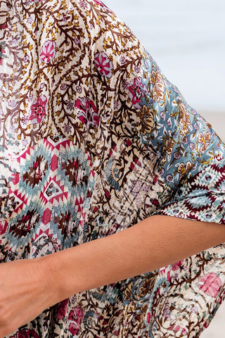 Close-up of a woman's arm wearing a Desert Bloom Kimono with a bohemian floral pattern.