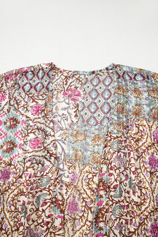 Close-up of a bohemian floral kimono with a patchwork design of pink, blue, and brown patterns.