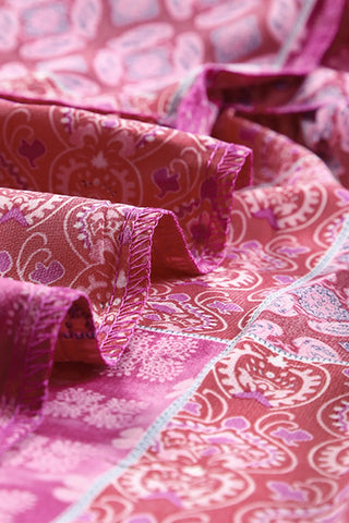Close-up of the Desert Bloom Maxi Skirt, showing its vibrant pink and red bohemian patchwork pattern.