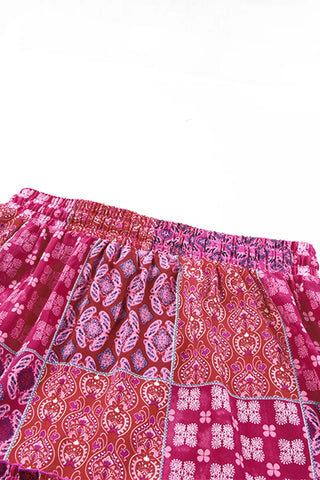 Close-up of a Desert Bloom Maxi Skirt, showing the elastic waistband and bohemian patchwork design in red and pink.