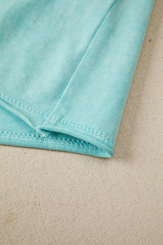 Close-up of the Desert Sky Raglan Tee, showing the washed teal fabric and white stitching detail.