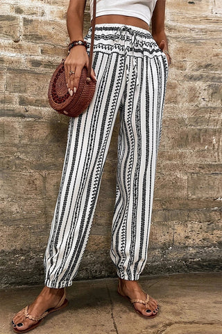A woman wears Desert Wanderer Striped Pants, featuring black and white boho striped lounge pants.