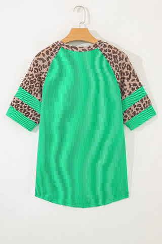 Back of a green ribbed top with leopard print raglan sleeves and two green stripes on each sleeve.