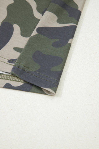 Close-up of Desert Trail Camo Shorts fabric, showing green, brown, and tan camouflage pattern with stitching.