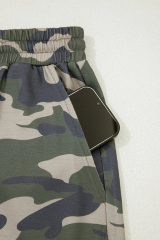Close-up of Desert Trail Camo Shorts with a phone in the pocket, showing the elastic waistband and camo pattern.