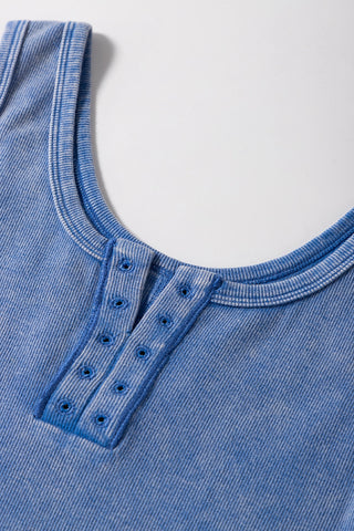Close-up of a dusty blue ribbed Henley tank with a button placket and scoop neckline.