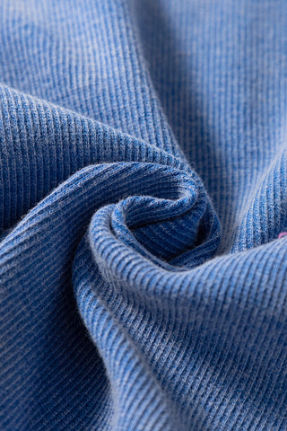 Close-up of the dusty blue ribbed Henley tank fabric, showing its soft texture and vertical ribbing.