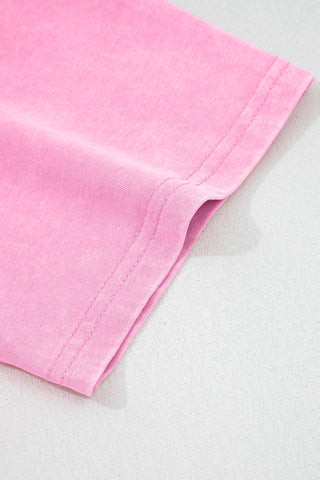 Close-up of the dusty rose pocket top, showing the fabric texture and stitching detail of the pocket.