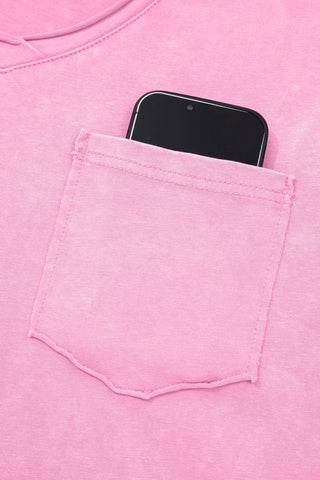 Close-up of a dusty rose pocket top with a phone in the chest pocket, showing the acid wash texture.