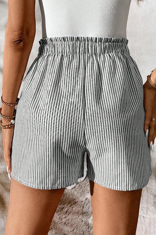 Close-up of a woman wearing Fresh Linen Stripe Shorts with a comfortable elastic waistband.