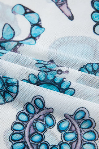Close-up of a white mesh Frontier Concho Tee with a repeating turquoise concho pattern.