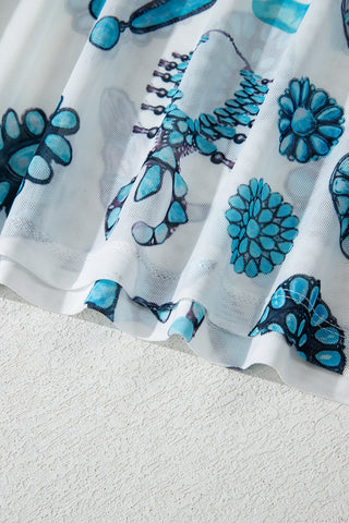 Close-up of the white Frontier Concho Tee fabric with blue turquoise concho designs.