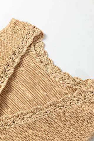 Close-up of a beige crochet knit tank top with intricate patterns and scalloped edges on a white background.