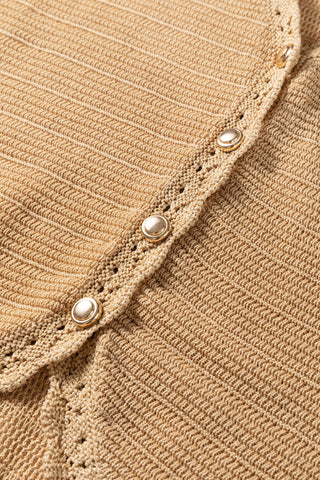 Close-up of a golden hour sleeveless top, showing the crochet knit texture and gold buttons.