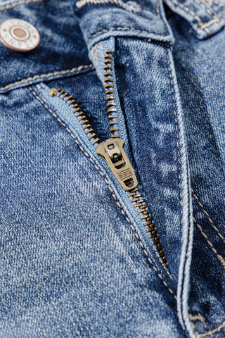 Close-up of Highway Honey Flare Jeans, showing the brass zipper and button on the distressed blue denim.
