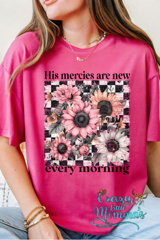 Pink "His Mercies Tee" with a checkered background and pink, peach, and white sunflowers.