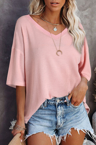 Woman wearing a Desert Rose Waffle Top, a light pink waffle knit top with a V-neck and short sleeves.