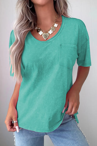 A woman models a Canyon Teal Pocket Top, a washed teal v-neck tee with a front pocket.