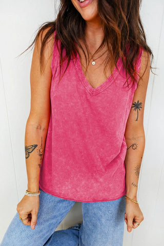 A woman wears a Canyon Rose Tank, a vintage fuchsia tank top with a V-neck, paired with light wash jeans.