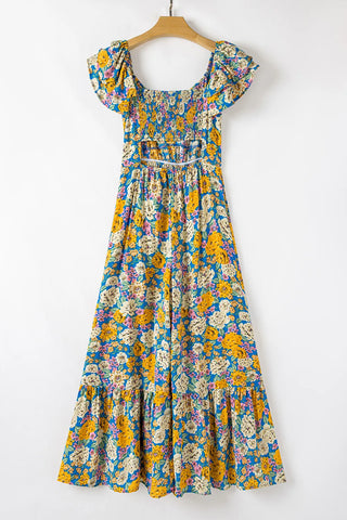 Blue floral smocked jumpsuit with yellow, white, and pink flowers, short sleeves, and a cutout back.