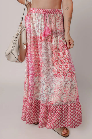 Wildflower Patchwork Maxi Skirt with pink tassels and a ruffled hem, featuring a boho floral pattern.