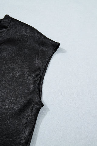 Close-up of a black shimmer draped blouse with a textured, slightly crinkled fabric.