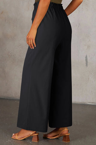 Woman wearing Midnight Prairie Wide Pants, showcasing the relaxed black palazzo pants with an elastic waist.