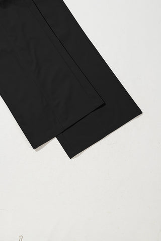 Close-up of the hem and lower leg of black wide-leg pants, showing a relaxed fit and subtle seam detail.