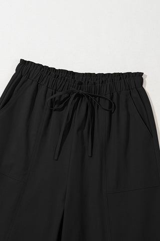 Close-up of Midnight Prairie Wide Pants, showing the elastic waistband with a tied drawstring and side pockets.