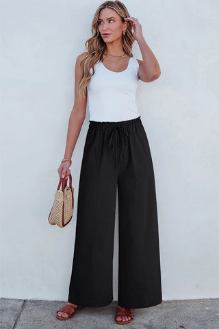 Woman in a white tank top and Midnight Prairie Wide Pants, relaxed black palazzo pants with a drawstring waist.