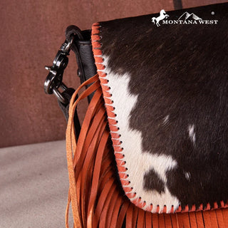 Close-up of a Montana West Cowhide Fringe Crossbody Purse. Black and white cowhide flap with orange fringe.