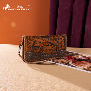Brown Montana West wallet with Aztec tooling, studs, and a wrist strap, on a light surface.