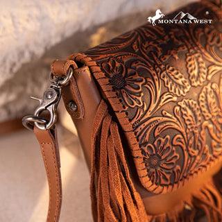 Close-up of a brown Montana West crossbody purse with intricate floral tooling and long fringe details.