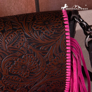 Close-up of a brown tooled leather crossbody purse with hot pink fringe and stitching along the side.