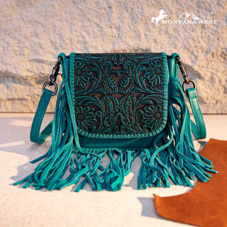 Turquoise Montana West crossbody purse with a tooled leather flap featuring floral designs and long fringe.