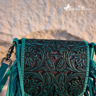 Close-up of a turquoise Montana West Tooled Leather Fringe Crossbody Purse with intricate floral and steer skull tooling.